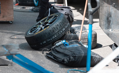 spare tires and automotive mechanic tools lay on roadside